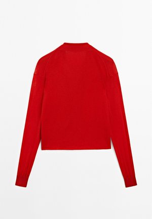 Rode langwerpige cropped trui met een ribbelstructuur, ronde hals en aansluitende mouwen. Heeft een strakke, eenvoudige ontwerp zonder versieringen.