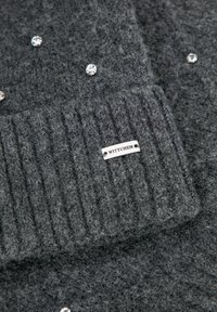 Szary dziergany sweter o prążkowanej fakturze, ozdobiony okrągłymi kryształami oraz srebrną metką z logo "WITTCHEN".
