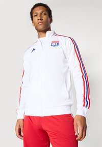 Weißer Zip-Jacke mit roten und blauen Streifen an den Ärmeln, mit einem gestickten Logo auf der Brust und einem Standard-Fit-Design.