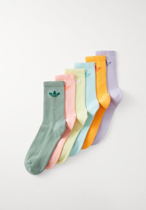 Set of seven ribbed socks in pastel colors: green, pink, yellow, light blue, orange, and lavender, featuring a leaf logo on the cuff.