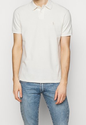 Jasnobeżowa koszulka polo z miękkiej bawełny, z klasycznym kołnierzykiem i krótkimi rękawami. Subtelne logo na piersi.