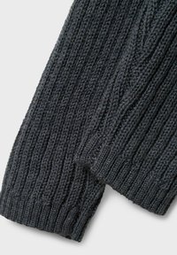 Tessuto lavorato a maglia grigio scuro con motivi a coste e treccia, mostrato in primo piano sulle estremità piegate del tessuto su uno sfondo bianco.