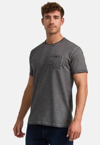 Grå kortærmet t-shirt lavet af tekstureret stof med en brystlomme og en dekorativ knap. Skåret i en klassisk pasform med en rund hals.
