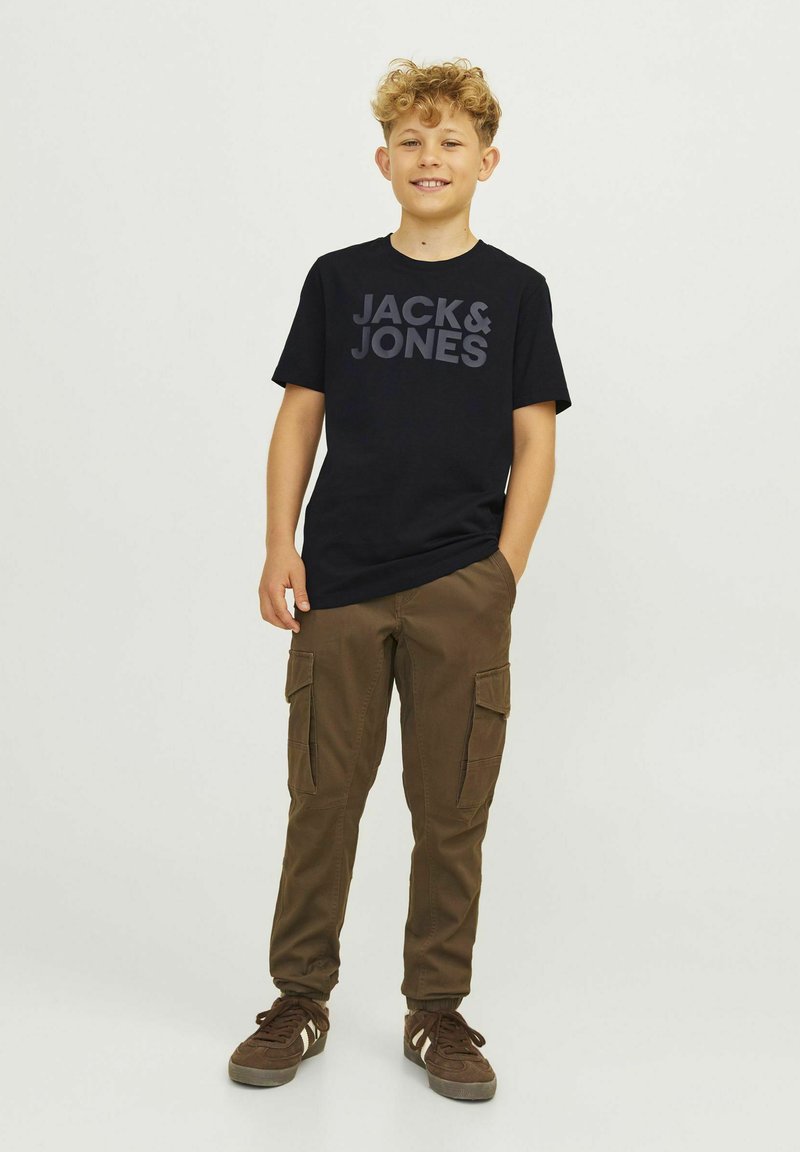 T-shirt preto de manga curta com "JACK & JONES" em texto cinza escuro, combinado com calças cargo castanhas com bolsos laterais e um corte relaxado.