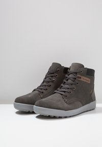 Szare zamszowe buty wysokie, z gumową podeszwą, wyposażone w metalowe oczka do sznurowadeł oraz akcent logo. Teksturowane wykończenie i wyściełany kołnierz.