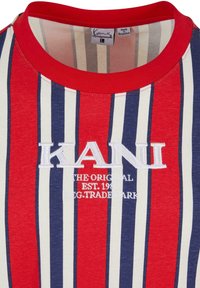 Röd, blå och vit randig T-shirt med ribbad rund hals och broderad "KANI"-logotyp. Mjukt bomullstyg med en slät textur.