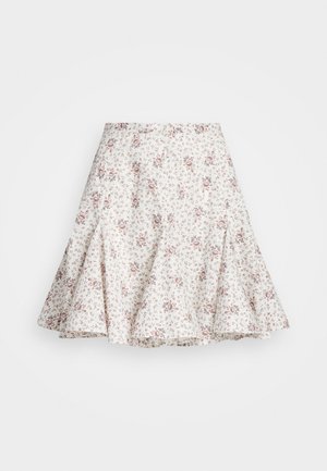 Jupe évasée blanche avec petit imprimé floral rouge et marron et détails de coutures créant un effet à étages.