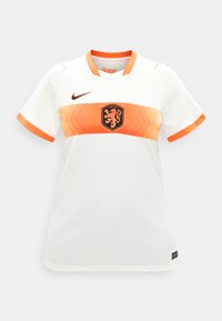 Λευκό αθλητικό μπλουζάκι με πορτοκαλί γιακά και άκρες μανικιών, με πορτοκαλί γεωμετρική ταινία και μαύρο έμβλημα λιονταριού στο κέντρο του στήθους.