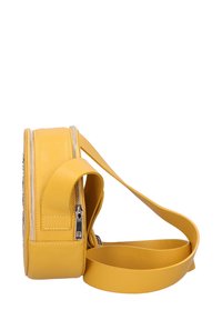 Borsa a tracolla gialla in pelle con forma rettangolare, dotata di cerniere in metallo argento e una tracolla lunga e regolabile. Dettaglio della superficie testurizzata.