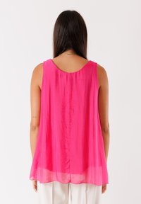 Tunika senza maniche di un vivace rosa, realizzata in un tessuto leggero e trasparente. Presenta un scollo rotondo e una caduta morbida sul retro.