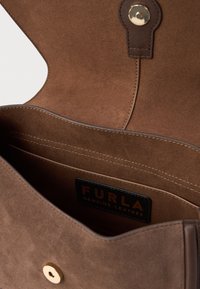 Prune suedes naha rahakoti sisemus, kus on magnetklipp ja Furla brändi silt sisepocketis.