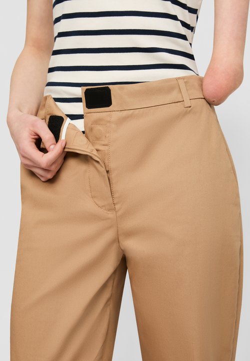 Pantaloni bej cu talie înaltă, având un front plat și închidere cu velcro. Materialul pare a fi neted și ușor.