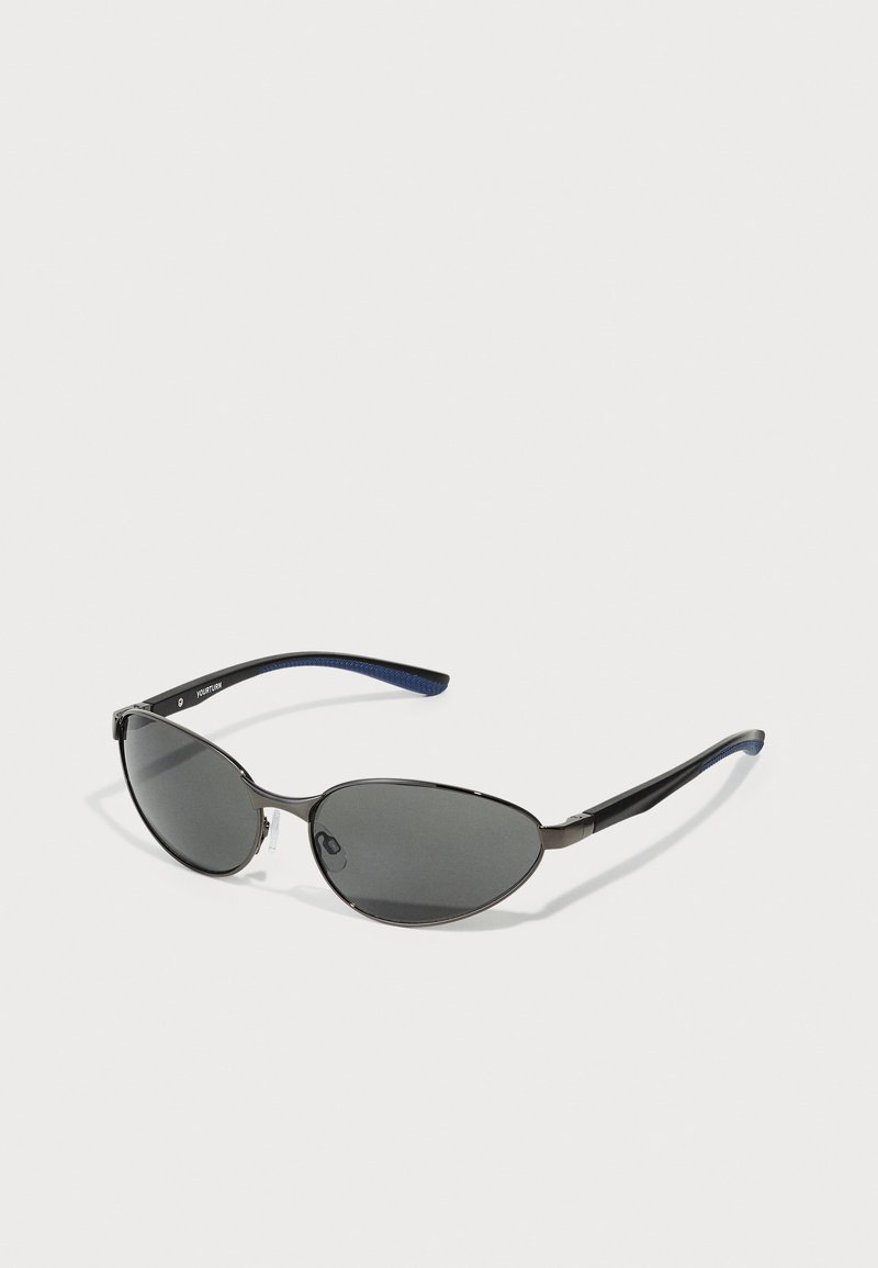 Óculos de sol com lentes ovais pretas, estrutura metálica e hastes texturizadas em preto e azul. Apresenta um logotipo em destaque de lado na armação.