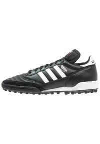 Botas de fútbol de cuero negro con franjas blancas, parte superior texturizada, punta redondeada, cierre de cordones en la parte delantera y suela de goma con tacos.