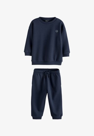 Mørkeblå sweatshirt med lange ærmer og matchende joggingbukser med elastisk talje samt lille smilende ansigt på brystet.