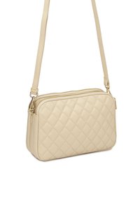 Borsa a tracolla imbottita in pelle beige con chiusura a zip, forma rettangolare piatta e una lunga tracolla regolabile. Dettagli in hardware color oro.