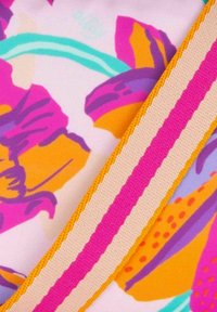 Levendige stof met grote, kleurrijke bloempatronen in roze, oranje en paars. Bevat een getextureerde, gestreepte accent in roze en beige.