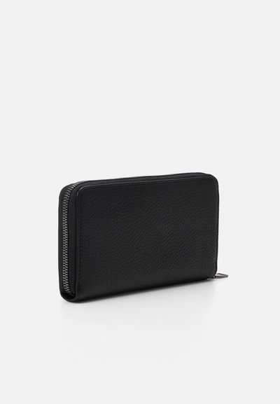 Portefeuille en cuir noir avec une finition texturée, de forme rectangulaire et une fermeture éclair argentée le long du bord. Design minimaliste sans logos visibles.