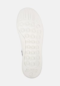 Suela de zapato blanca con patrones de tracción circulares y puntos elevados. Marcada con el tamaño "38" y el nombre de la marca "Camper" en relieve.