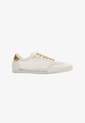 Zapatilla blanca de perfil bajo con cordones beige, detalle dorado en el talón y paneles laterales de malla transpirable para ventilación.