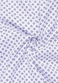Tessuto bianco con un motivo geometrico di piccoli quadrati blu contornati di blu scuro, con una superficie testurizzata visibile nella trama.