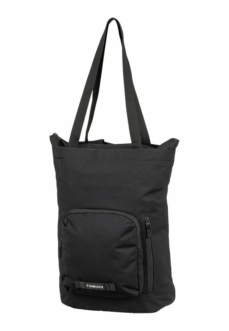 Bolsa tote de tela negra con asas dobles, que presenta un bolsillo frontal con cremallera y un diseño texturizado sutil. Cierre superior ajustable.