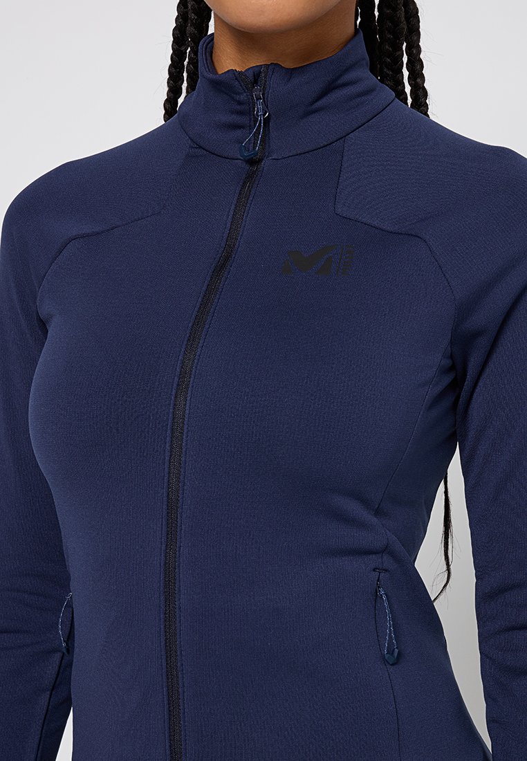 Giacca zip-up blu navy realizzata in tessuto morbido e strutturato, con colletto alto, tasche laterali e un piccolo logo nero sul petto.
