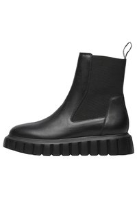 Černá kožená kotníková bota s elastickými bočními panely, texturovanou gumovou podrážkou a zadním poutkem pro snadné obouvání. Hladký povrch s masivním designem.