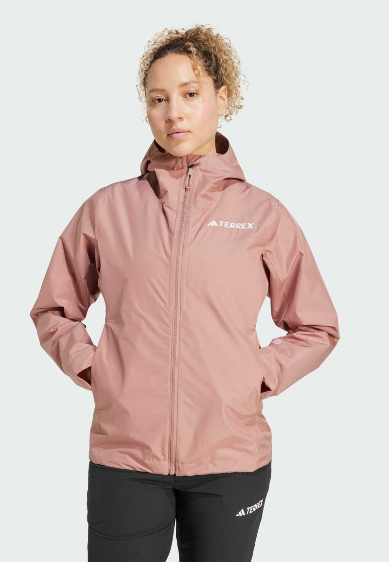 Giacca impermeabile rosa chiaro con zip frontale, cappuccio regolabile e logo sul lato sinistro del petto. Tessuto liscio e leggero; vestibilità rilassata.