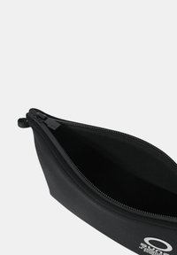 Astuccio per matite in neoprene nero con chiusura a zip, dotato di una texture liscia e un logo stampato in bianco su un lato.