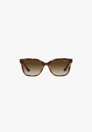 Gafas de sol de carey con lentes marrones degradados. Forma de ojo de gato, montura de plástico y detalle sutil del logo en la parte superior izquierda de la montura.