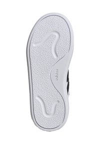 Scarpa nera con suola in gomma bianca. La suola presenta un motivo testurizzato con un design ondulato distintivo e il marchio "adidas" vicino al tallone.