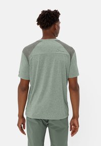 Camisetta verde melange a maniche corte con maniche raglan grigie, dettagli delle cuciture e un logo discreto sulla parte alta della schiena. Realizzata in tessuto leggero.