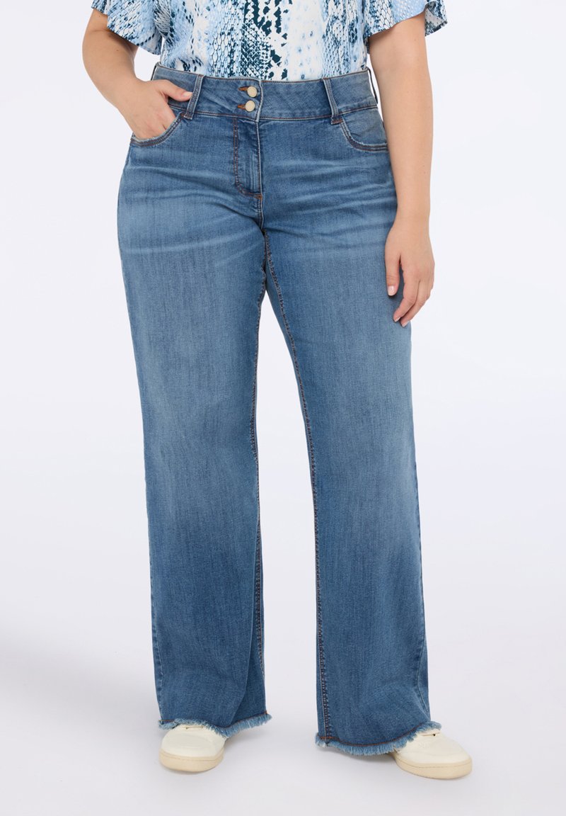 Jeans de pierna ancha en denim suave de color azul con una cintura alta, que cuentan con dos cierres de botón, dobladillos deshilachados y bolsillos frontales.