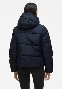 Tumesinine puffjakktaga, mis on varustatud kapuutsi ja quiltitud osadega, lühendatud pikkusega ning elastsete mansettidega, valmistatud siledast isoleeritud materjalist.