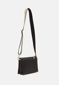 Borsa a tracolla rettangolare nera con chiusura a zip e tracolla regolabile, caratterizzata da strisce beige e nere.