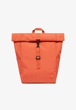 Mochila naranja con tapa enrollable, hebilla metálica negra y correa frontal, bolsillos laterales y un asa superior, sobre un fondo blanco.