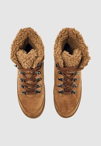 Brune suede vandrestøvler med en fluffy brun inderside, metaløjer og brune snørebånd, designet til udendørs brug.