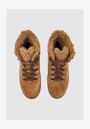 Bruine leren wandelschoenen met een pluizige bruine voering, metalen oogjes en bruine veters, ontworpen voor buitengebruik.