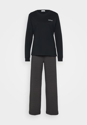 Musta pitkähihais shirt, jossa on valkoinen logo, yhdistettynä leveälahkeisiin housuihin musta-valkoisella geometrisella kuviolla. Pehmeä kankaan rakenne.