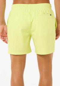 Bañador amarillo brillante con una cinturilla elástica, bolsillos laterales y un bolsillo trasero, hecho de una tela ligera y suave.