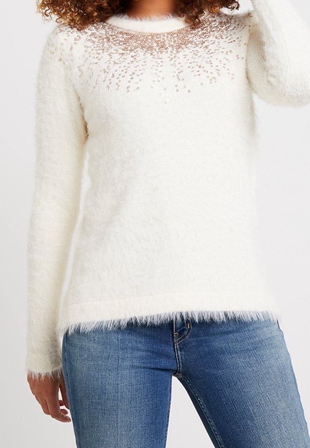 Pörröinen valkoinen neule, jossa on pyöreä pääntie, koristeltu sotkuisilla paljeteilla V-muotoisessa kuviossa hartioilla; pehmeä rakenne.