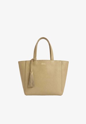 Sac fourre-tout en cuir beige avec deux poignées et un pompon décoratif suspendu à une poignée, sur fond blanc.