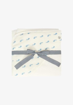 Coperta per neonati in cotone, crema con stampa di balene azzurri, rifinita con una morbida texture. Legata con un nastro a righe blu e bianche.