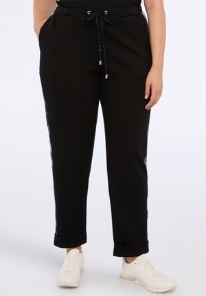 Pantaloni jogger neri con cintura regolabile, orli a costine, tasche laterali e accenti blu a motivo lungo i lati. Tessuto morbido.