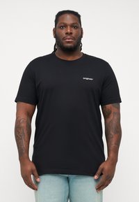 Schwarzes Baumwoll-T-Shirt mit kurzen Ärmeln, Rundhalsausschnitt, mit einem kleinen weißen "Originals"-Logo auf der linken Brustseite.