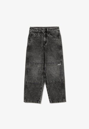 Pantalons en denim noir au fit ample, présentant une finition délavée, des coutures visibles, des poches avant et un petit logo au niveau du genou gauche.