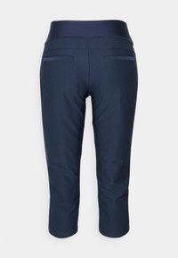 Námořnické modré zkrácené kalhoty se strečovým pasem a zadními kapsami, zobrazené ze zadní strany na jednobarevném pozadí.