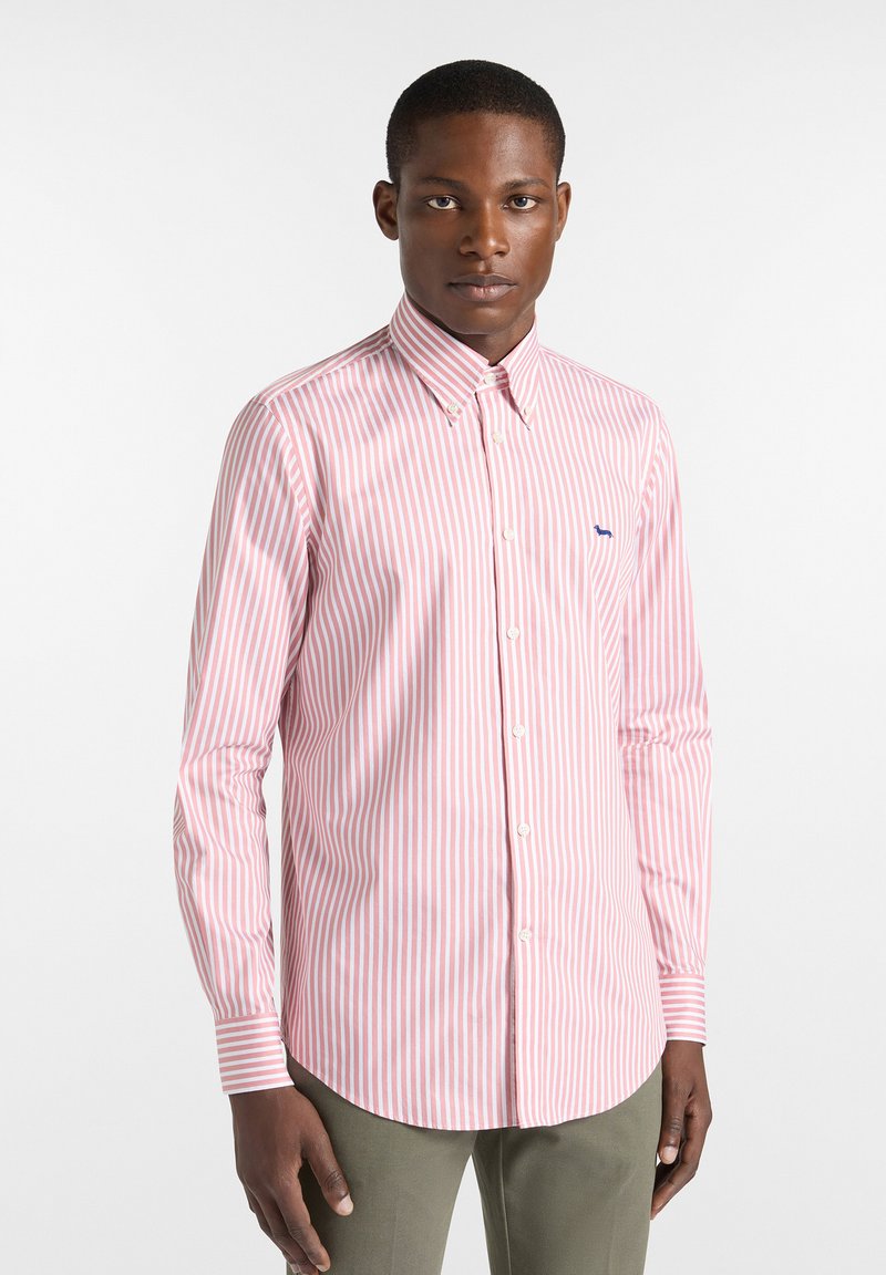 Camisa de algodón a rayas en rosa y blanco, con cuello abotonado, mangas largas y un pequeño logo azul en el lado izquierdo del pecho.