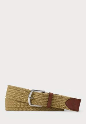 Flätad tanfärgad tygbälte med silvermetalldolk och bruna läderdetaljer, inklusive ett broderat logomärke i slutet.